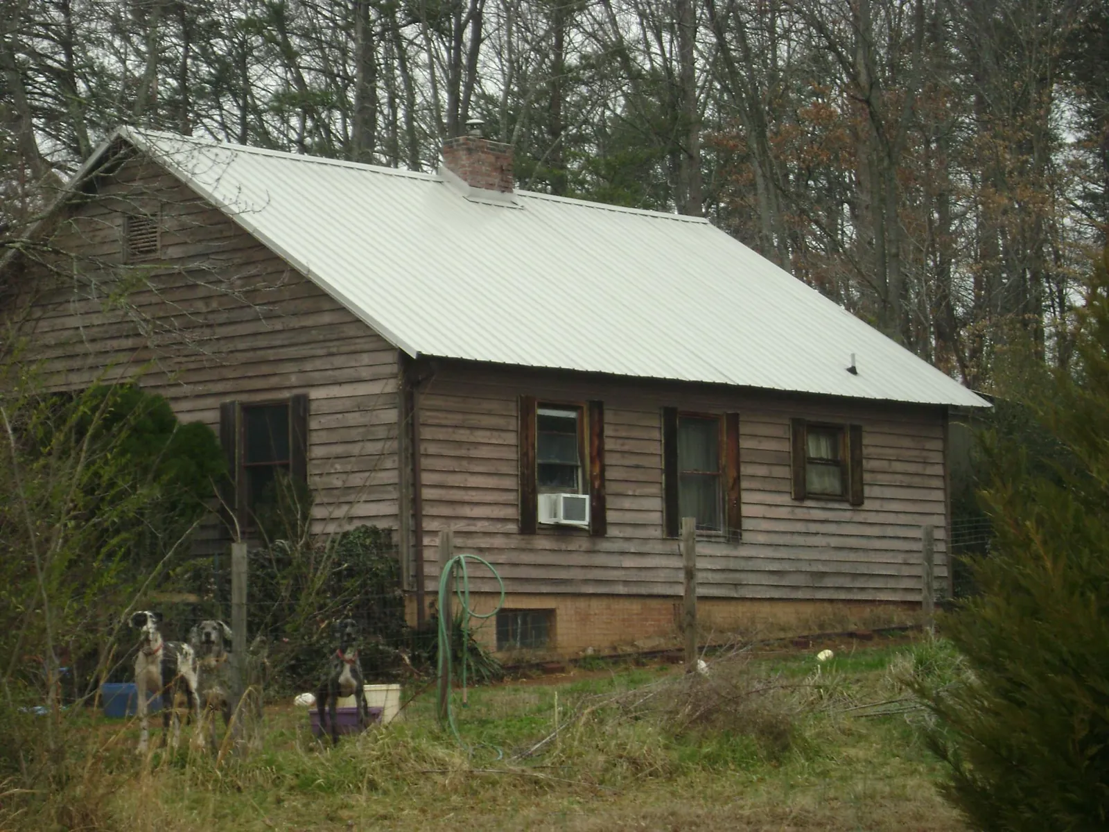 White metal roof on an old wood sided farmhouse, from a Metal Roof Installation job in Mc Intosh